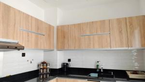 a kitchen with wooden cabinets and a sink at Dar Amora in Ras El Ma +5 photos