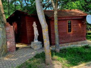 a statue in front of a small red building at Krolichya ferma in Ivancea