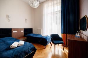 a bedroom with two beds and a chair and a window at Nowy Dom Zdrojowy in Krynica Zdrój