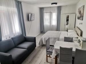 a bedroom with a bed and a couch and a table at Paulina Harmony Rooms in Seget Vranjica