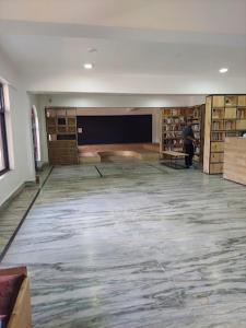 uma grande sala com uma pessoa em pé numa biblioteca em Hotel Pinnacle em Palampur