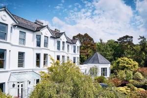 a white house with a garden in front of it at Seaview House Hotel in Bantry