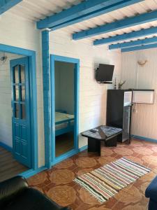 a living room with a blue door and a tv at Popas Turistic Alex in Murighiol
