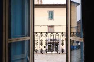 ein offenes Fenster mit Blick auf einen Balkon in der Unterkunft Albergo Della Posta in Bracciano