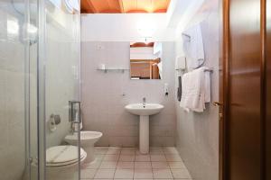 y baño con aseo y lavamanos. en Albergo Della Posta, en Bracciano