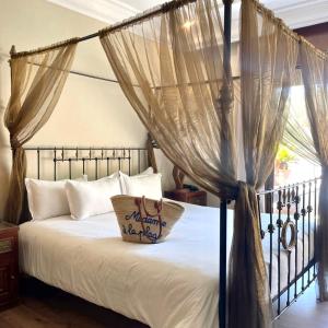 a bedroom with a canopy bed with a pillow on it at The Red House in Marrakesh