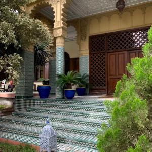 una veranda anteriore di una casa con vasi blu di The Red House a Marrakech