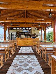 ein leeres Restaurant mit Holztischen und Bänken in der Unterkunft Family Hotel Komhotel in Berkowiza