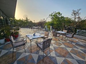 un patio con tavoli e sedie su un pavimento piastrellato di Hotel The Bundela - Khajuraho, Madhya Pradesh a Khajurāho