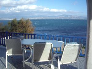 un tavolo e sedie su un balcone con vista sull'oceano di Καραμπεικο a Piso Livadi