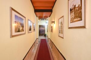 a long hallway with paintings on the walls at Albergo Della Posta in Bracciano