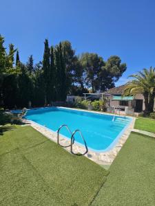 a large blue swimming pool in a yard at Villa Lazaro in Alfacar