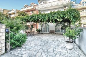 an outdoor patio with a stone floor and a building at Sun Guest House in Budva