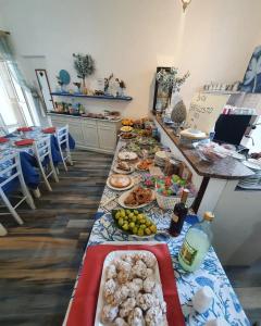 una mesa larga con muchos platos de comida. en Mir Mar, en Lampedusa