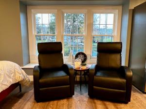 dwa krzesła i stół w sypialni z oknami w obiekcie Turner Park Suite w mieście Montour Falls