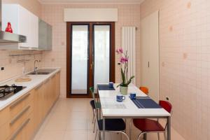 a kitchen with a table with chairs and a sink at Di Ale Elegant House in Chioggia