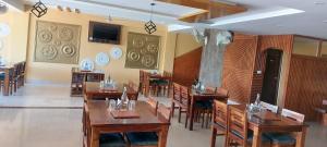 comedor con mesas y sillas de madera en Hotel Saint, en Pālampur