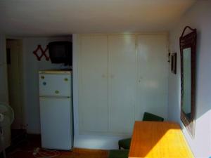 a kitchen with a refrigerator and a cupboard at Καραμπεικο in Piso Livadi