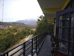 balcón con vistas a la carretera y a las montañas en Hotel Saint, en Pālampur