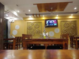 comedor con mesa y TV en la pared en Hotel Saint, en Pālampur