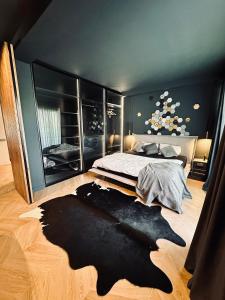 a bedroom with a bed and a large black rug at Shades of Cluj Napoca in Cluj-Napoca