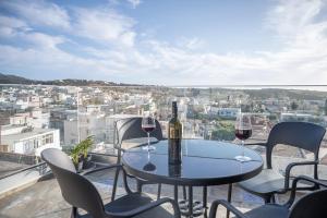 a table with two glasses of wine on a balcony at Iglesia Kefalos in Kefalos