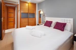 a bedroom with a large white bed with purple pillows at Boliches Mediterraneo Real Tropical Coast by Alfresco Stays in Las Lagunas Mijas +46 photos