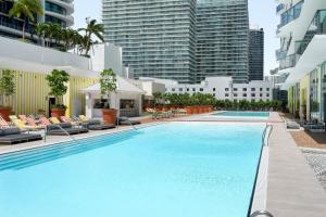 una grande piscina con sedie a sdraio e edifici di DUA Miami, Autograph Collection a Miami