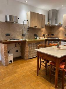 a large kitchen with a table and chairs in it at Antica Fonte Eterna - Casale in incantevole contesto Toscano in Colle di Val d'Elsa