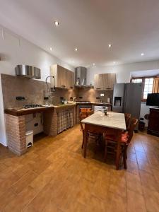a kitchen with a table and chairs and a refrigerator at Antica Fonte Eterna - Casale in incantevole contesto Toscano in Colle di Val d'Elsa +11 photos