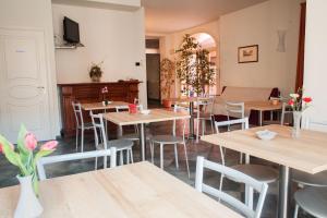 Albergo del muletto في Villanova dʼAsti: مطعم بطاولات وكراسي خشبية وتلفزيون