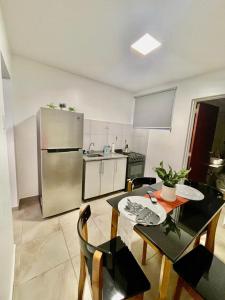 a kitchen with a table and a stainless steel refrigerator at Hermoso Departamento en Vicente lopez in Vicente López