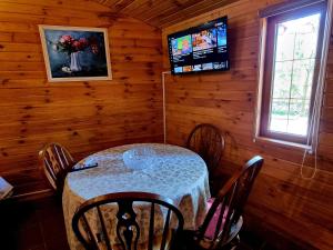 a dining room with a table and a television in a cabin at Krolichya ferma in Ivancea