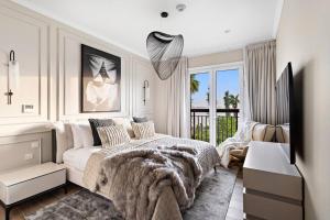 a white bedroom with a large bed and a window at World Class VILLA Exclusive & Seaside Splendor in Dubai