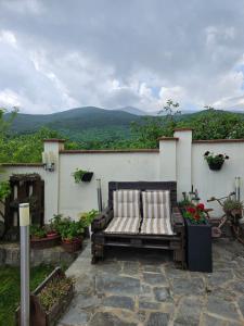 a bench on a patio with a view of a mountain at Family Hotel Komhotel in Berkovitsa