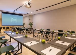 a conference room with tables and a projection screen at Zenit Coruña in A Coruña