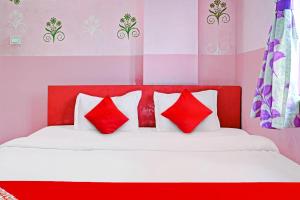 uma cama vermelha e branca com almofadas vermelhas e brancas em Flagship Star Guest House em Calcutá