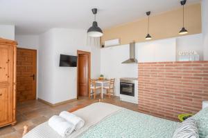 ein Schlafzimmer mit einer Ziegelwand und einem Tisch mit Handtüchern in der Unterkunft CHIC APARTAMENTS in Tossa de Mar