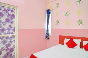 um quarto com paredes cor-de-rosa e roxo e uma cama em Flagship Star Guest House em Calcutá