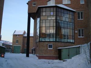 a large brick building with snow in front of it at Severniy Hotel in Ukhta