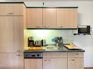 a kitchen with wooden cabinets and a sink at Haus Inge in Heringsdorf