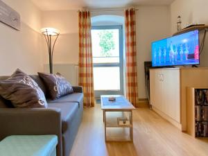 ein Wohnzimmer mit einem Sofa und einem TV in der Unterkunft Haus Inge in Heringsdorf