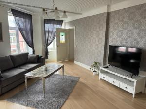ハープサルにあるKarja Apartment with saunaのソファと薄型テレビのあるリビングルーム