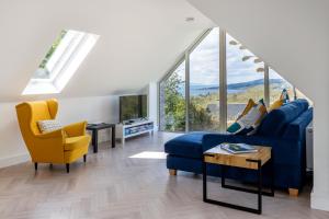 sala de estar con sofá azul y sillas amarillas en Patch House Glengarriff en Glengarriff