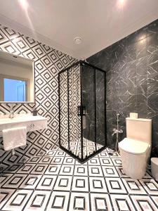 ein Bad mit einer Dusche, einem WC und einem Waschbecken in der Unterkunft Maestro Address Hotel in Baku