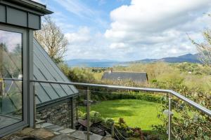 a balcony with a view of a yard at Patch House Glengarriff in Glengarriff
