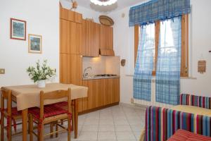 a small kitchen with a table and a refrigerator at Agriturismo Al Vermigliano in Alberese