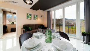 een eetkamer met een tafel en stoelen en een bank bij Wonder Home - Apartamenty w malowniczej okolicy z balkonami i widokiem na góry in Karpacz