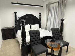 Korean Hotel Resort في Tây Ninh: غرفة نوم بسرير وطاولة وكراسي