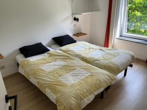 sypialnia z 2 łóżkami i oknem w obiekcie Gîte « Chez Mémé » w mieście Nassogne